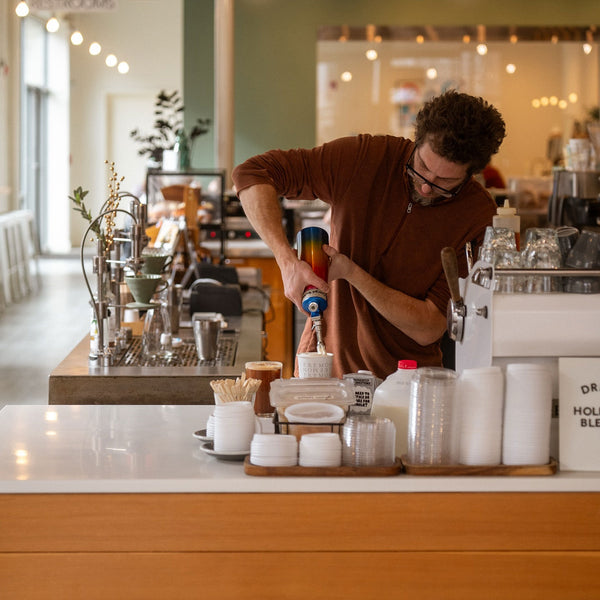 Barista preparing a coffee drink in a modern cafe.