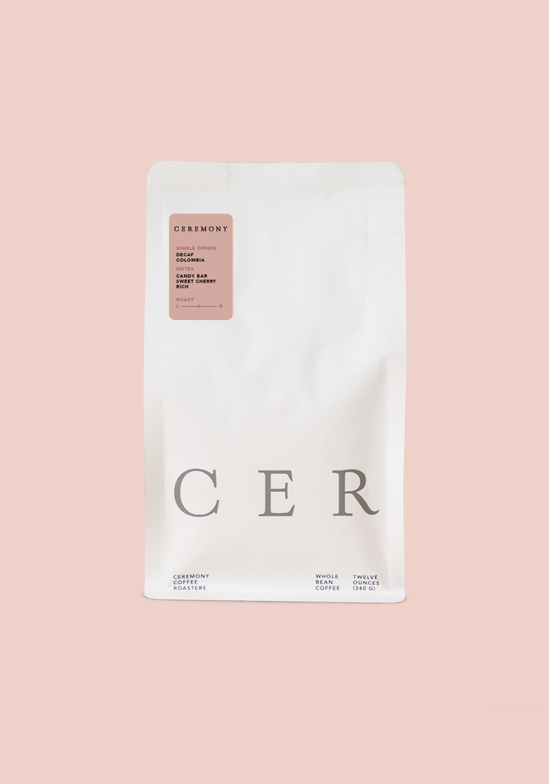 Decaf EA Colombia whole bean coffee with candy bar and sweet cherry flavor notes in minimalist white packaging
